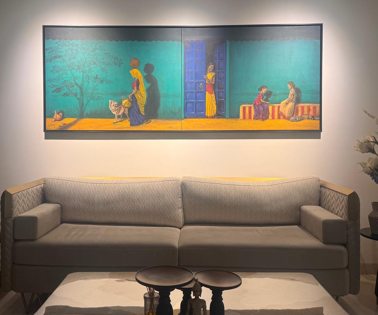A wide two-panel painting of village life on a turquoise wall, hung above a grey sofa